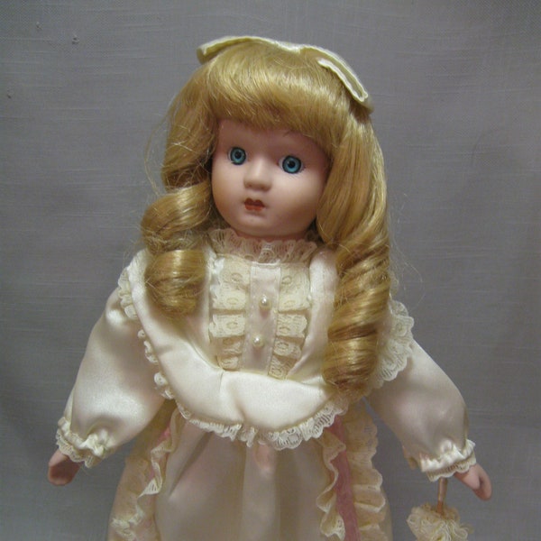 Porcelain Doll Blond Hair Blue Eyes Soft Ivory Dress With Flower Lace Bow On Head Umbrella to Match White Tie Shoes Pink Trim Doll Stand