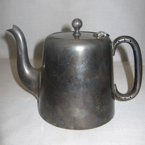 May include: A silver teapot with a hinged lid and a rounded body. The teapot has a spout and a handle.