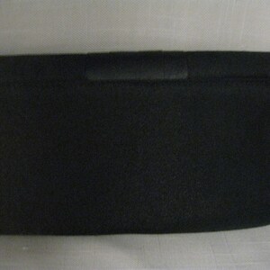 May include: A black fabric clutch purse with a simple design.