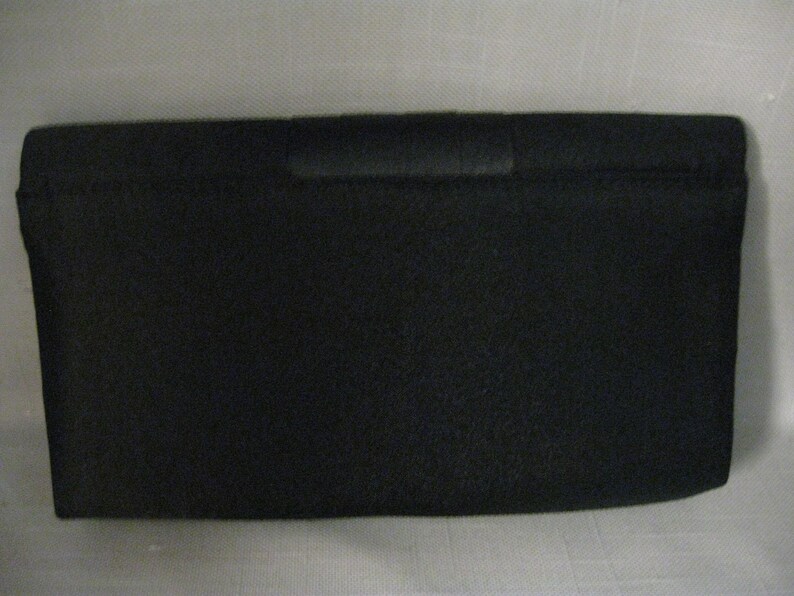 May include: A black fabric clutch purse with a simple design.