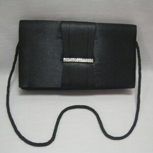 May include: A black satin clutch bag with a rhinestone embellishment and a long black strap.