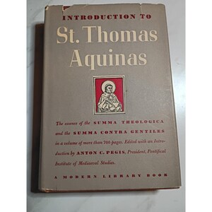 May include: A hardcover book titled Introduction to St. Thomas Aquinas with a grey cover, cream-colored text, and a central illustration of a saint in a red frame. The cover includes text referencing the Summa Theologica and Anton C. Pegis.