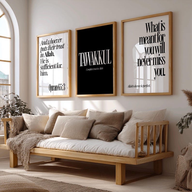 May include: Three framed wall art pieces with inspirational quotes in black and white. The middle frame is black with the word "TAWAKKUL". The other two frames have white backgrounds with quotes. A wooden daybed with pillows is in the foreground.