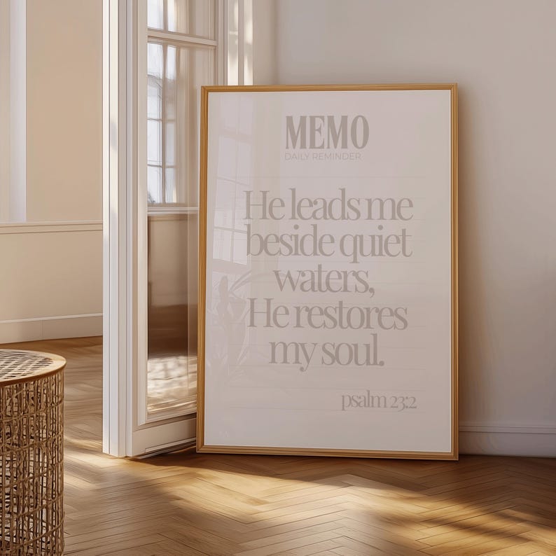 Może przedstawiać: Oprawiony wydruk z tekstem "MEMO DAILY REMINDER" i cytatem z Psalmu 23:2: "Prowadzi mnie nad wody spokojne, odnawia moją duszę." Rama jest w kolorze jasnobrązowym.