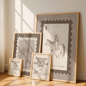 May include: Four framed art prints with a vintage postage stamp theme. The prints feature sepia-toned illustrations of cowboys, horses, and text. One print reads "Freedom Begins Where Fear Ends."
