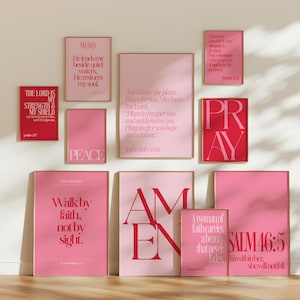 Puede incluir: Una colección de impresiones artísticas enmarcadas en tonos rosa y rojo, con citas inspiradoras y versículos religiosos. Las impresiones varían en tamaño e incluyen frases como "Pray", "Amen" y "Walk by faith".