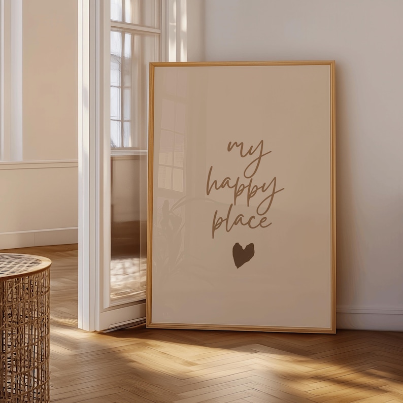 Pode incluir: Impress&atilde;o emoldurada com a frase "my happy place" em estilo manuscrito, acompanhada por um pequeno cora&ccedil;&atilde;o. A obra de arte tem uma paleta de cores neutras e &eacute; exibida em uma sala clara.