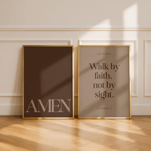 May include: Two framed art prints with gold trim. One print is a solid dark brown with the word "AMEN" in light beige. The other print is light beige with the text "Walk by faith, not by sight." and "2 Corinthians 5:7."