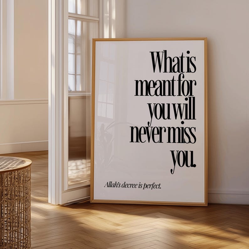 May include: A framed print with the text "What is meant for you will never miss you." The print is in a wooden frame and features a minimalist design with black text on a white background. The phrase "Allah's decree is perfect" is at the bottom.
