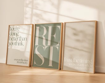 Puede incluir: Tres impresiones artísticas enmarcadas con citas inspiradoras. La primera impresión dice "You're doing better than you think" en texto negro. La segunda impresión dice "REST" en letras grandes. La tercera impresión dice "Trust the timing."