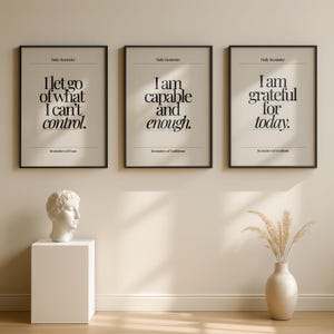 May include: Three framed prints with black frames and beige backgrounds. Each print features a different inspirational quote in black text: "I let go of what I can't control," "I am capable and enough," and "I am grateful for today."