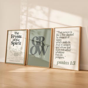 Può includere: Tre stampe artistiche incorniciate con citazioni ispiratrici e illustrazioni botaniche. La prima stampa recita "I frutti dello Spirito" con un elenco di virtù e Galati 5:22-23. La seconda stampa dice "GROW IN GRACE". La terza stampa ha una citazione dal Salmo 1:3.