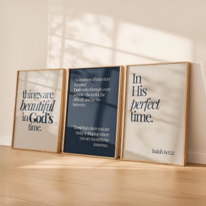 May include: Three framed art prints with inspirational quotes. The prints have gold frames and feature text in a serif font. The first print says "things are beautiful in God's time." The second print has a navy background and the third print says "In His perfect time."