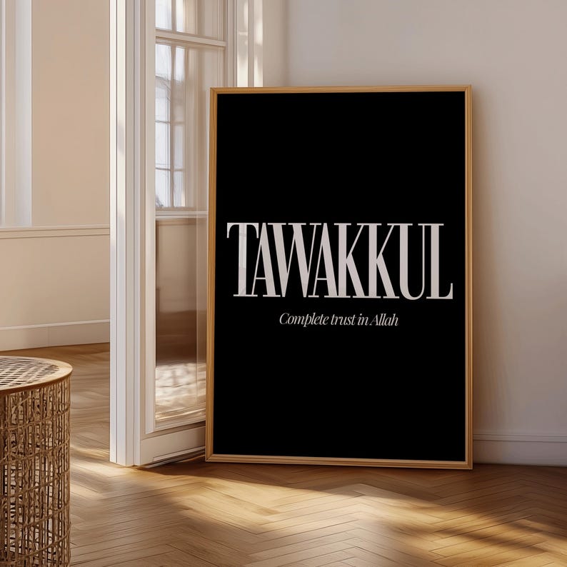 May include: A framed black art print with the word "TAWAKKUL" in large, white, serif font. Below, in a smaller font, it reads "Complete trust in Allah". The print is in a light wood frame.