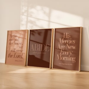 Op de afbeelding: Drie ingelijste kunstdrukken met inspirerende citaten in een warm kleurenpalet. De prints bevatten zinnen als "As for me and my house, we will serve the Lord", "ABIDE where peace lives" en "His Mercies Are New Every Morning."