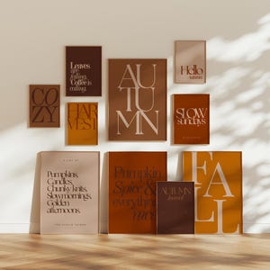 Könnte beinhalten: Ein Galerie-Wandset aus zehn rechteckigen Postern in Braun-, Orange- und Cremetönen. Die Drucke zeigen Typografie mit Schriftzügen wie Autumn, Fall, Harvest, Cozy, Hello Autumn, Slow Sundays sowie Listen mit saisonalen Begriffen in verschiedenen Schriftarten.