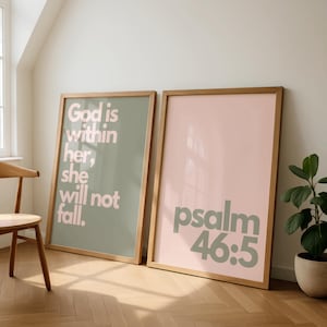 Puede incluir: Dos impresiones artísticas enmarcadas con citas inspiradoras. Una impresión tiene el texto "God is within her, she will not fall" en rosa claro sobre un fondo verde salvia. La otra impresión dice "psalm 46:5" en verde salvia sobre un fondo rosa.