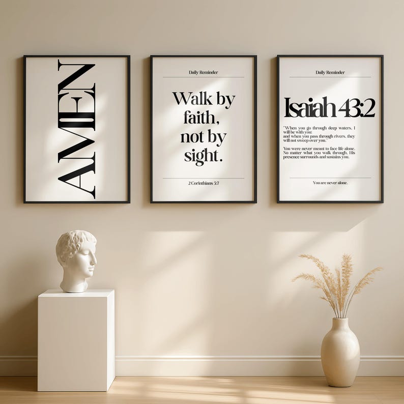 K&ouml;nnte beinhalten: Drei gerahmte Kunstdrucke mit schwarzen Rahmen. Der erste Druck sagt "AMEN" in gro&szlig;en, fetten Buchstaben. Der zweite Druck lautet "Walk by faith, not by sight." Der dritte Druck zeigt "Jesaja 43:2" mit einem Bibelvers.