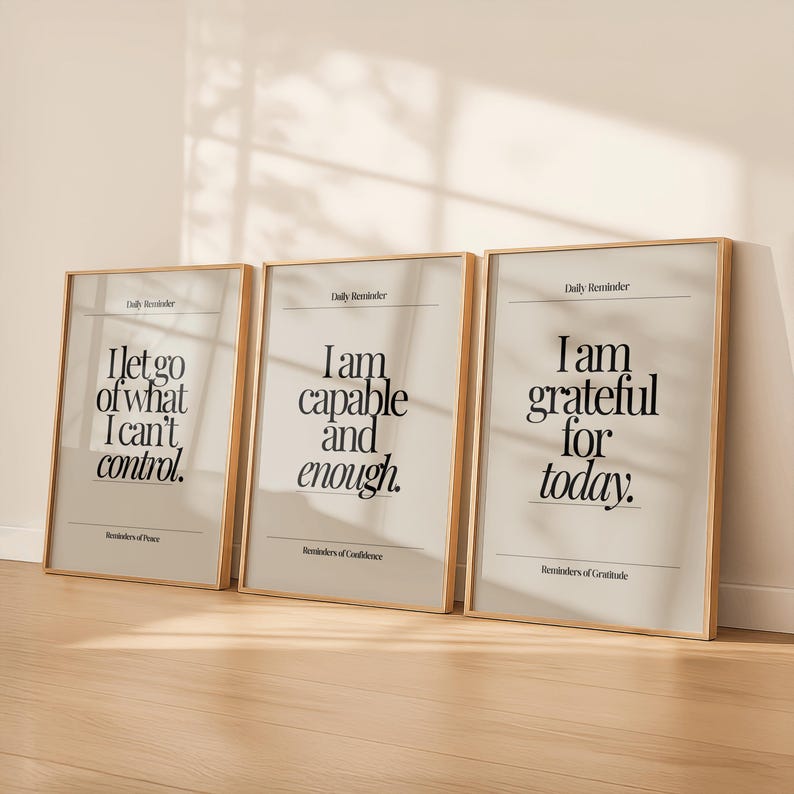May include: Three framed art prints with inspirational quotes. The prints have a light beige background with black text. The first print reads "I let go of what I can't control." The second print reads "I am capable and enough." The third print reads "I am grateful for today."