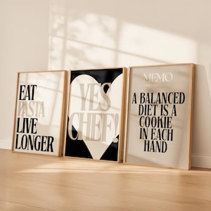 Peut inclure: Trois affiches encadrées avec des citations humoristiques. La première dit "EAT PASTA LIVE LONGER". La deuxième dit "YES CHEF!" sur une forme de cœur. La troisième dit "A BALANCED DIET IS A COOKIE IN EACH HAND".
