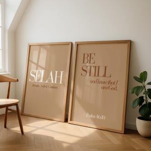 May include: Two framed art prints with inspirational quotes. One print reads "SELAH" with "Breathe. Reflect. Continue." below. The other says "BE STILL and know that I am God." with "Psalm 46:10" at the bottom. Both have a tan background and wooden frames.