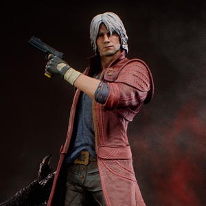 Puede incluir: Figura detallada de un personaje de la serie de videojuegos Devil May Cry. La figura viste un abrigo rojo, una camisa azul y pantalones oscuros, sosteniendo una pistola. La figura se encuentra sobre una base rocosa con detalles rojos brillantes. El logotipo de KC Studio es visible.