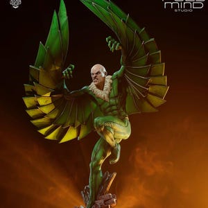 May include: A detailed statue of a comic book character, the Vulture, in a dynamic pose. The figure is predominantly green with yellow accents on the wings. The character is depicted with a bald head and a menacing expression. The statue is on a rocky base.