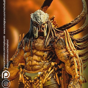 Peut inclure: Sculpture détaillée d'un extraterrestre Predator, avec une armure complexe et un masque menaçant. La figurine est principalement marron et beige, avec des dents acérées et des dreadlocks. Le fond est orange chaud.