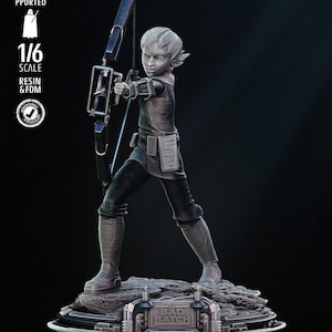 Peut inclure: Figurine détaillée à l'échelle 1/6 en résine et FDM d'un personnage de "Bad Batch" tenant un arc et une flèche. La figurine est dans une pose dynamique, debout sur une base texturée avec les mots "Bad Batch". La figurine est de couleur gris clair.