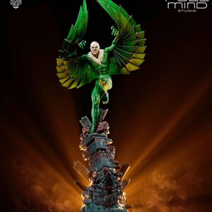 May include: A detailed statue of the Vulture, a comic book villain, with green and yellow wings outstretched. The figure is posed atop a crumbling brick structure. The statue is from Poly Mind Studio.