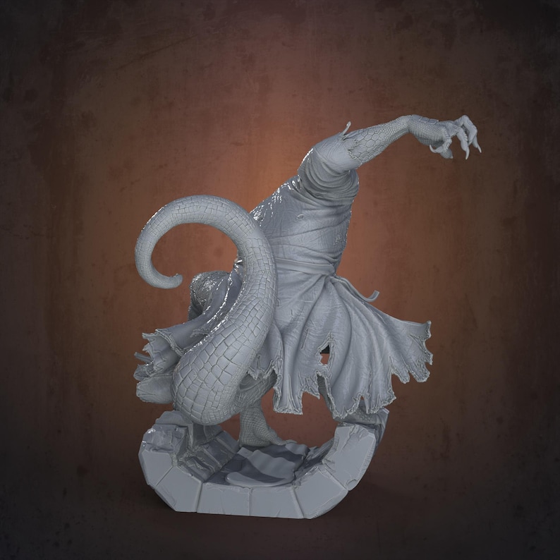 Peut inclure: Sculpture grise d'une cr&eacute;ature avec une queue serpentine et une main griffue. La figurine est drap&eacute;e dans un tissu d&eacute;chir&eacute; et se tient sur une base en pierre. La sculpture a une surface textur&eacute;e et d&eacute;taill&eacute;e.