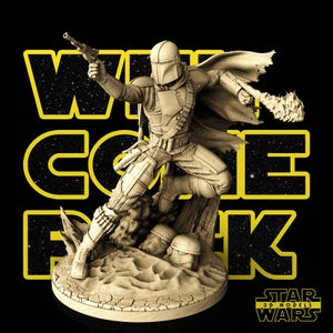 May include: A beige Mandalorian figurine in a dynamic pose, holding a blaster and a weapon, set against a black background with yellow text that reads "WELCOME BACK". The base features two helmets and the Star Wars logo.