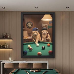Könnte beinhalten: Ein Raum mit einem Billardtisch mit grünem Filz und einem dunklen Holzrahmen. Ein großes gerahmtes Kunstwerk zeigt zwei Katzen beim Billardspielen. Der Raum verfügt über eine Bar mit Flaschen und eine Sitzecke mit einem grauen Sofa.