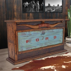 May include: A rustic wooden cabinet with a distressed blue front panel featuring the red letters "FORD." The cabinet is adorned with a carved wooden steer horn and is set against a dark wood backdrop. The cabinet is a unique piece of furniture.