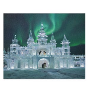 以下が含まれることがあります： ペンギンがいる氷の城を描いたジグソーパズル。城は照らされており、背景には緑色のオーロラがあります。パズルはテクスチャ加工された表面です。