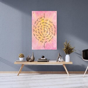 May include: A pink and yellow abstract art print with a spiral design in the center. The artwork is mounted on a wall above a wooden table with decorative items. The room has a modern aesthetic.