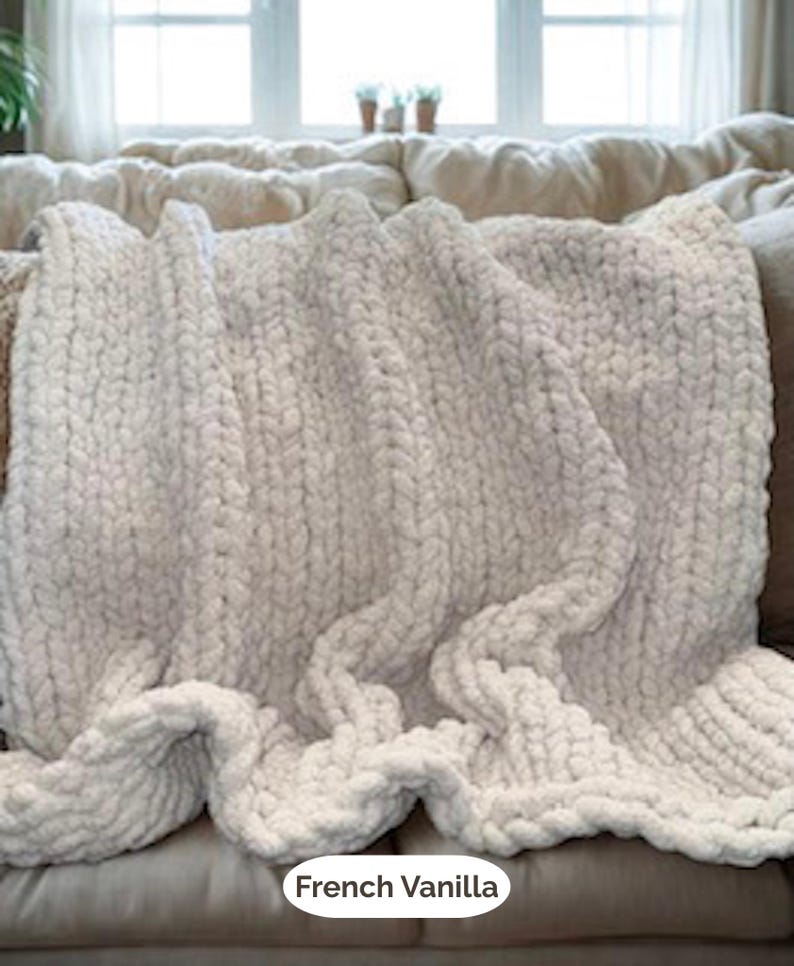 Hand-knit chunky blanket in French Vanilla, a soft creamy off-white tone, draped on a neutral sofa for cozy minimalist home decor.