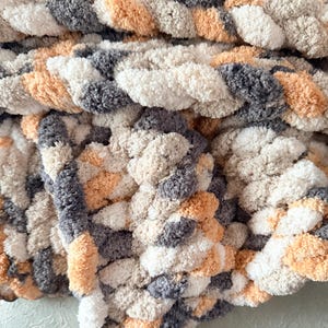 Detailed view of Toasted Birch chunky knit blanket with thick braided texture in warm neutral tones of ivory, tan, and charcoal gray.