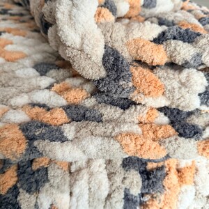 Rolled corner of chunky Toasted Birch blanket highlighting thick braided texture and plush softness in neutral tones.