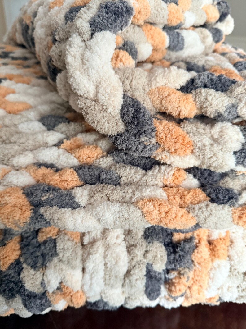 Rolled corner of chunky Toasted Birch blanket highlighting thick braided texture and plush softness in neutral tones.