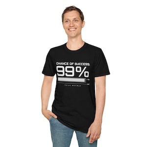 Könnte beinhalten: Schwarzes T-Shirt mit weißem Text "CHANCE OF SUCCESS: 99%". Darunter befindet sich eine Fortschrittsbalken-Grafik und der Text "IT FAILS ANYWAY". Das T-Shirt ist ein Rundhals-Modell.