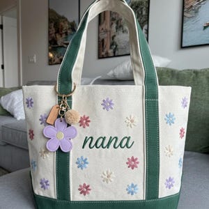 Make this Mother's Day unforgettable with our Personalized Daisy Embroidered Boat Tote. Designed for the "Nana" or "Gigi" who loves a touch of floral elegance, this heavyweight canvas bag combines practical durability with the delicate charm of hand-digitized embroidery.
