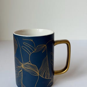 Djupgrön keramisk mugg, guldfärgad botanisk linjekonst, guldfärgad kaffekopp med handtag