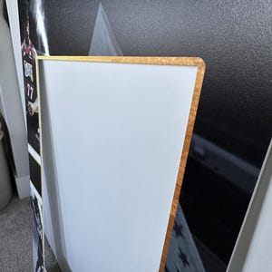 May include: A framed sports print featuring a basketball player in a red and black jersey with the number 17. The frame has a gold-colored edge and a white border. The background is black and white.