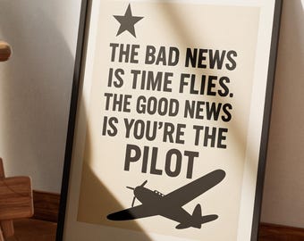 Pode incluir: Impressão artística emoldurada com moldura preta. A impressão tem um fundo bege com texto preto que diz: "THE BAD NEWS IS TIME FLIES. THE GOOD NEWS IS YOU'RE THE PILOT." Uma estrela e uma silhueta de avião também estão presentes.