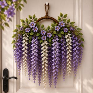 Könnte beinhalten: Ein kreisförmiger Kranz mit herabhängenden Trauben aus violetten und weißen Glyzinienblüten, akzentuiert durch kleine violette Blüten und grüne Blätter. Das Arrangement ist an einem braunen, runden Rahmen befestigt und bildet ein florales Dekor.