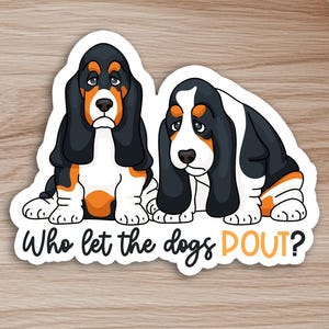 May include: A sticker featuring two cartoon basset hounds with sad expressions. The dogs are black, white, and orange. The text "Who let the dogs DOUT?" is written in a playful font below the dogs.