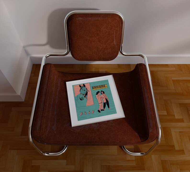 May include: A brown leather chair with a chrome frame. A framed print with a horse illustration and figures is on the seat. The chair is positioned against a white wall and a wooden floor.