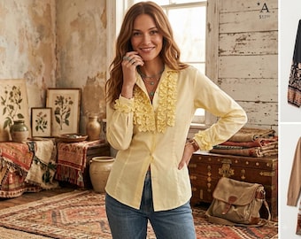 May include: A pale yellow long-sleeved button-down shirt featuring a vertical ruffled placket down the front and matching ruffled cuffs. The shirt is paired with blue denim jeans, creating a classic look with a structured collar and buttoned front.