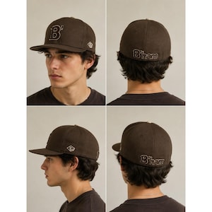 Puede incluir: Una gorra de béisbol de color marrón oscuro con visera plana y corona estructurada. La parte delantera muestra una letra B grande bordada con un apóstrofo. El lateral presenta un pequeño logotipo en forma de rombo y la parte trasera B'ham.